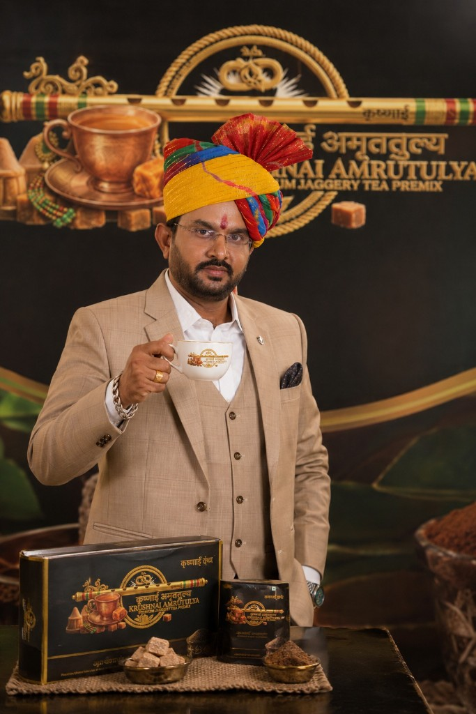 Vinod Bhanaram Parihar wearing traditional Rajasthani safa, holding Krushnai Amrutulya product boxes